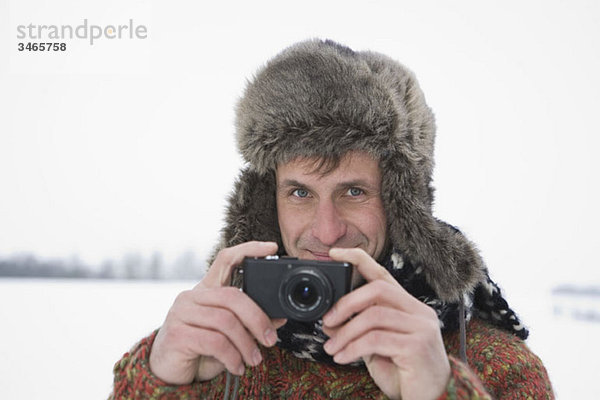 Ein Mann fotografiert mit einer Digitalkamera  im Freien  Porträt