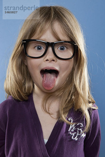Ein junges Mädchen  das spielerisch die Zunge herausstreckt  Studioaufnahme