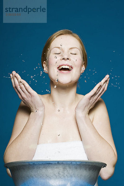 Eine Frau  die sich das Gesicht wäscht.