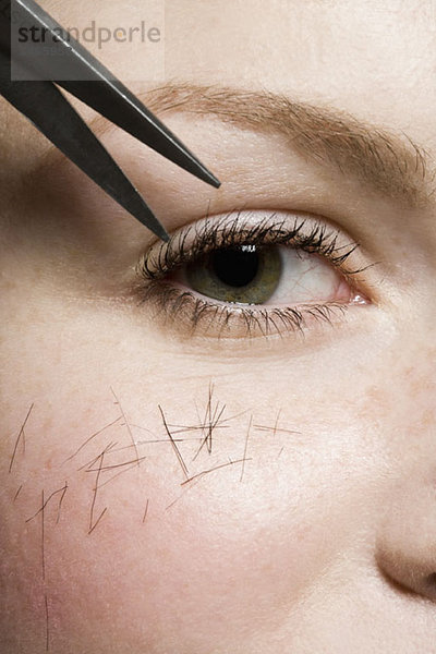 Schere schneidet Haare an einer Frau  Detailaufnahme des Auges