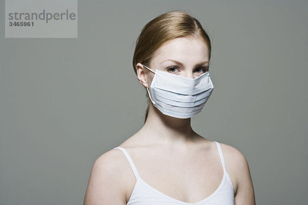 Eine Frau mit einer chirurgischen Schutzmaske