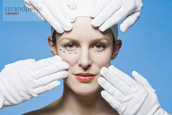 Zwei Mitarbeiter im Gesundheitswesen  Detail der Hände  Vorbereitung einer Frau für die plastische Chirurgie  Kopfschuss