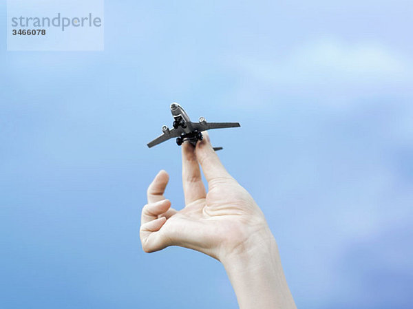 Eine Frau  die ein Modellflugzeug hält  Detail der Hand  flacher Blickwinkel