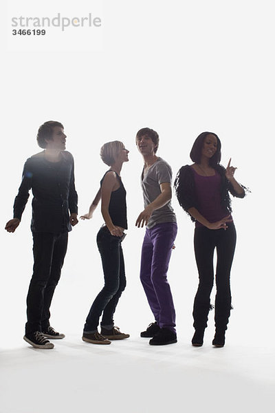 Vier junge Leute tanzen  Studioaufnahme  weißer Hintergrund  hinterleuchtet
