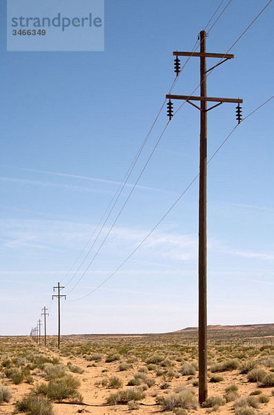 Eine Reihe von Strommasten in der Wüste