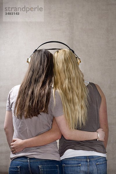 Teenagerinnen teilen sich Kopfhörer