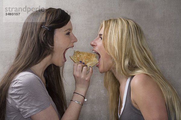 Teenagermädchen teilen sich ein Sandwich