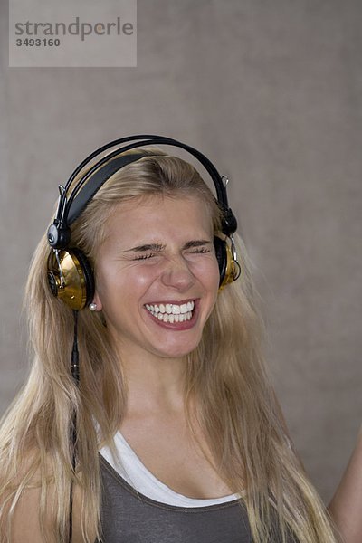 Teenagerin lächelt mit Kopfhörern