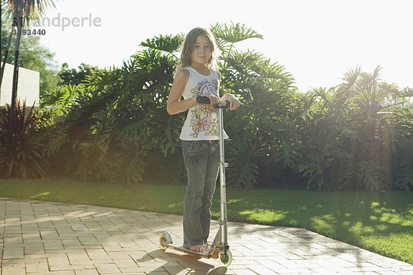 Mädchen auf dem Roller stehend