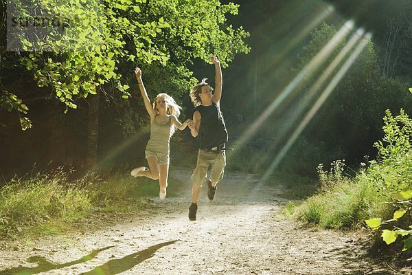 Junges Paar beim Springen im Wald