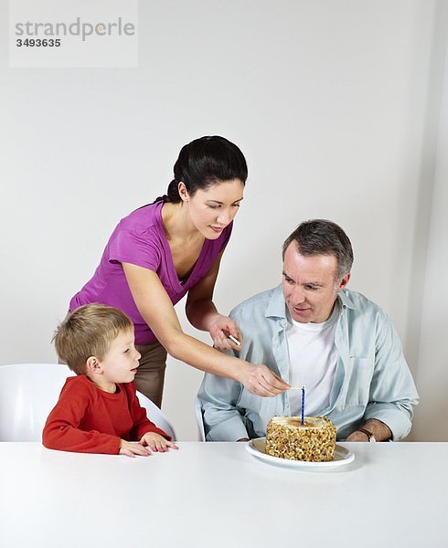 Paar und kleiner Sohn mit Geburtstagskuchen