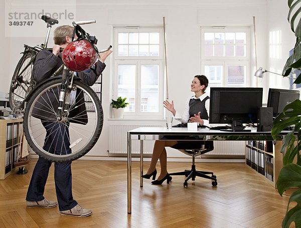 Geschäftsleute im Büro mit Fahrrad