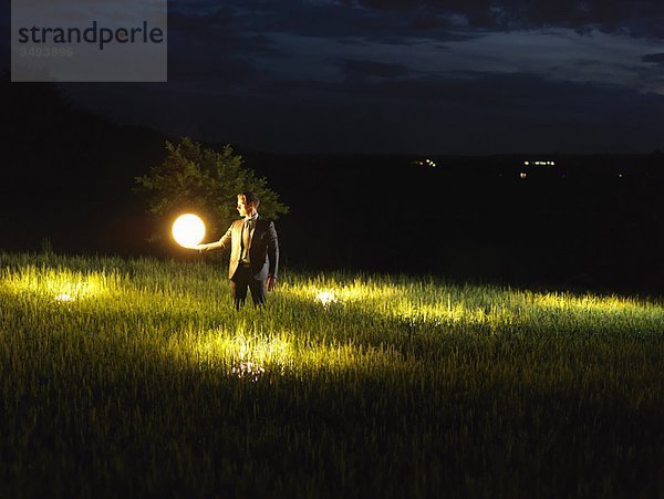 Geschäftsmann hält eine Lampe hoch