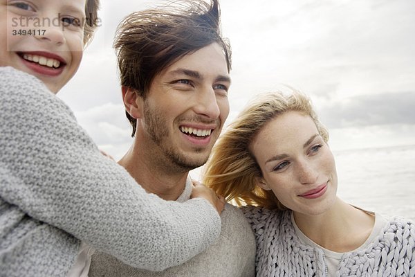 Junge Familie am Strand im Herbst