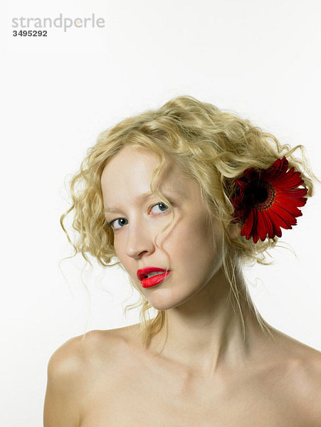Junge Frau mit roter Blume im Haar