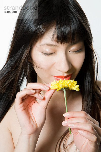 Junge Frau riecht Blume