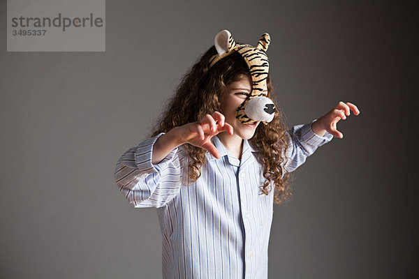 Junges Mädchen mit Tigermaske  brüllend