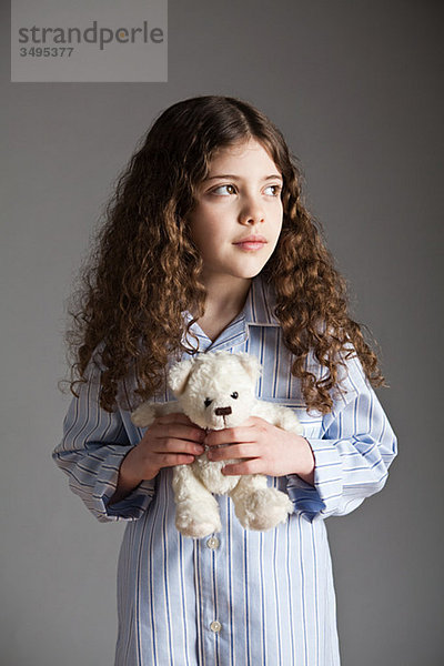 Junges Mädchen im Schlafanzug mit Teddybär
