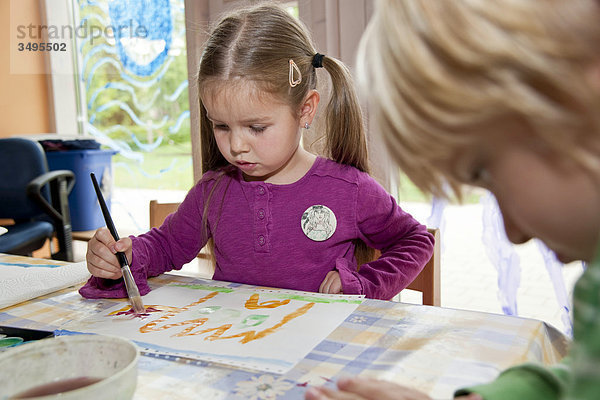 Mädchen und Junge malen im Kindergarten