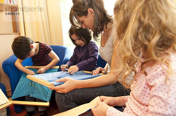 Kindergärtnerin und Kinder spielen mit Verschlussrahmen