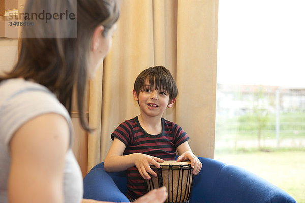 Junge musiziert mit Kindergärtnerin