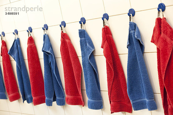 Handtücher hängen in einer Reihe an der Wand