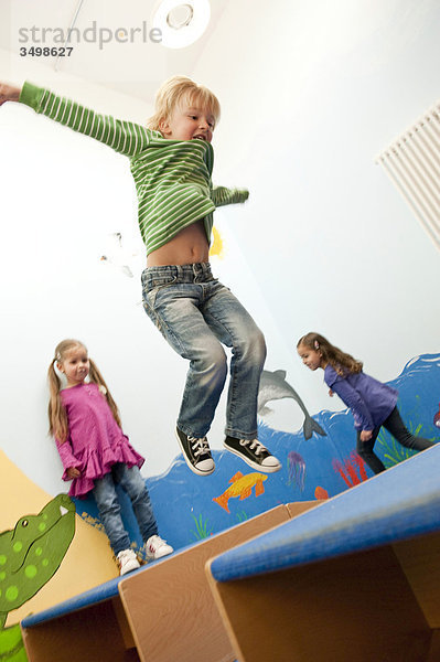 Kinder springen über Kästen  Flachwinkelansicht