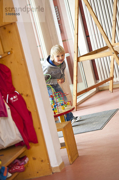 Junge spielt im Korridor eines Kindergartens