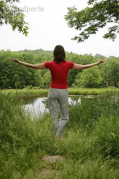 Frau meditiert in der Natur  Rückansicht