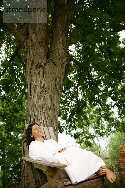 Frau in einer Liege vor einem Baum