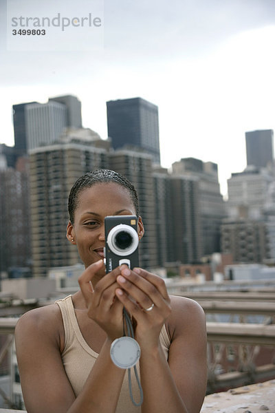 Frau fotografiert mit einer Kamera  New York Skyline im Hintergrund  USA