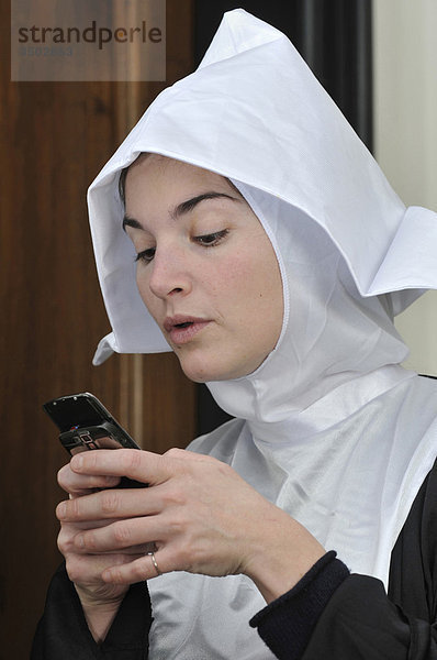 Junge Nonne mit mobile