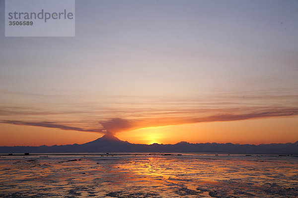 Aschewolke erhebt sich vom Mount Redoubt bei Sonnenuntergang bei Ebbe in der Nähe von Ninilchik  Alaska