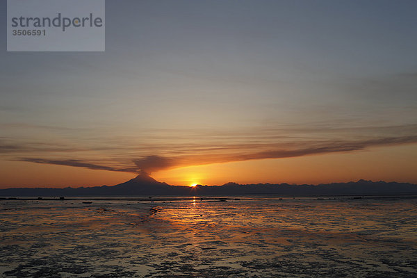 Aschewolke erhebt sich vom Mount Redoubt bei Sonnenuntergang bei Ebbe in der Nähe von Ninilchik  Alaska