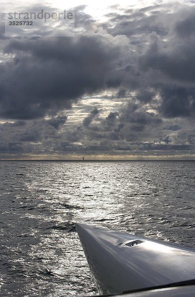 Gewitterwolken über Himmel und Boot im Meer