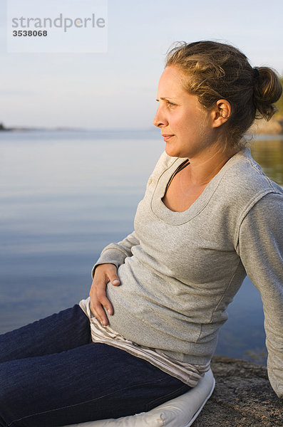 Schwangere Frauen Gefühl ihrem Magen und betrachten anzeigen
