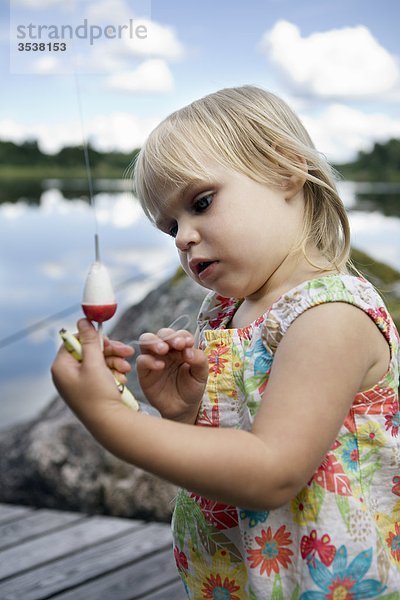 Mädchen betrachten Fischerei-Haken