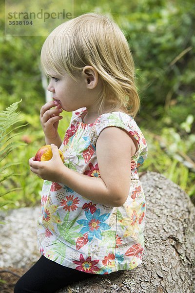 Kleine Mädchen hält Pfirsich