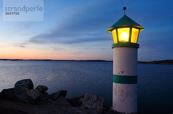 Skandinavien  Schweden  Vastkusten  Ansicht von beleuchteten Leuchtturm am Meer