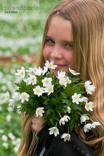 Skandinavien  Schweden  Smaland  Mädchen hält Bund weiße Anemonen  Portrait  Nahaufnahme