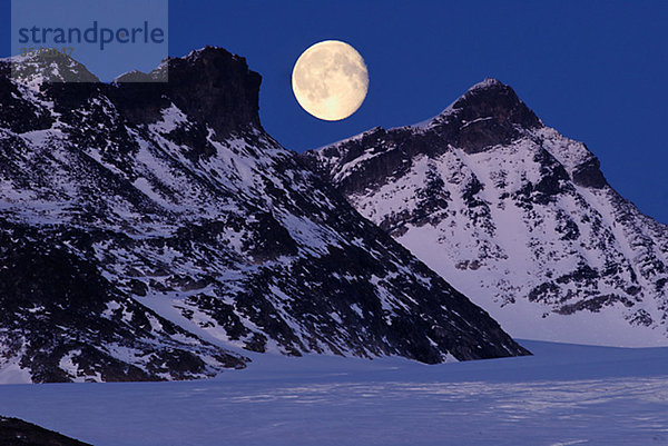 Skandinavien  Norwegen  schneebedeckte Berge mit Mond im Hintergrund