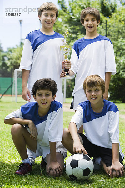 Junge Mannschaftskameraden posieren mit Trophäe  Portrait