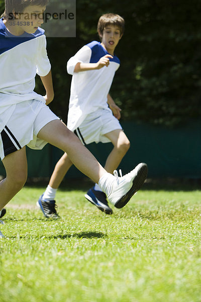 Jungen  die auf dem Fußballfeld laufen