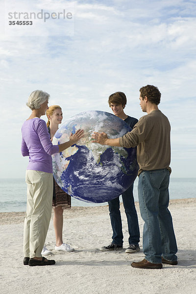 Ökologiekonzept  vier Menschen legen gemeinsam die Hände auf die Erde