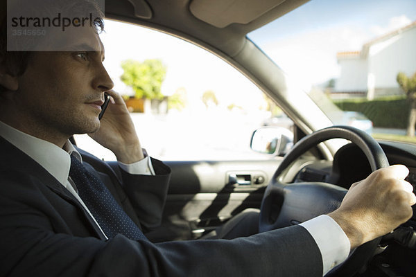 Geschäftsmann mit Handy während der Fahrt