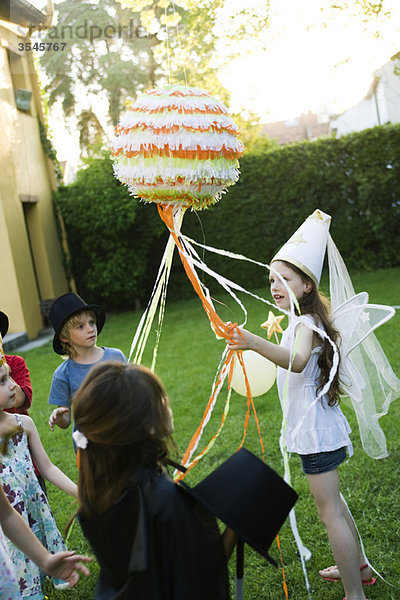 Kinder ziehen Luftschlangen an der Zugschnur pinata