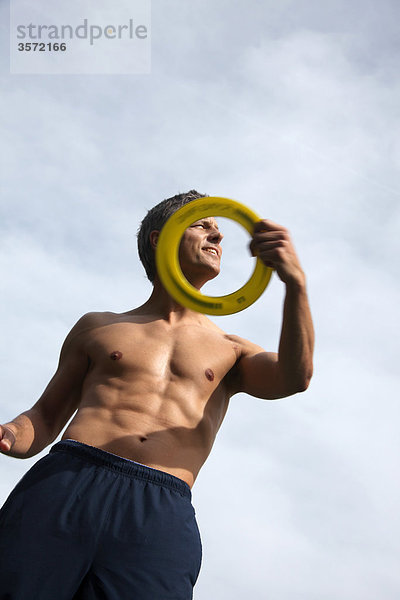 Mann wirft Frisbee im Freien