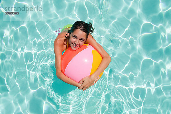 Junge Frau im Schwimmbad mit Strandball