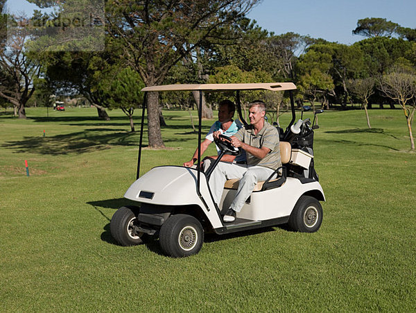 Zwei reife Männer im Golfwagen auf dem Golfplatz