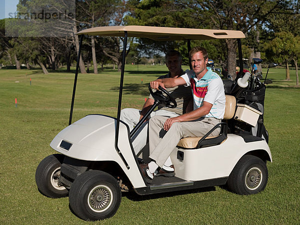 Zwei reife Männer im Golfwagen auf dem Golfplatz